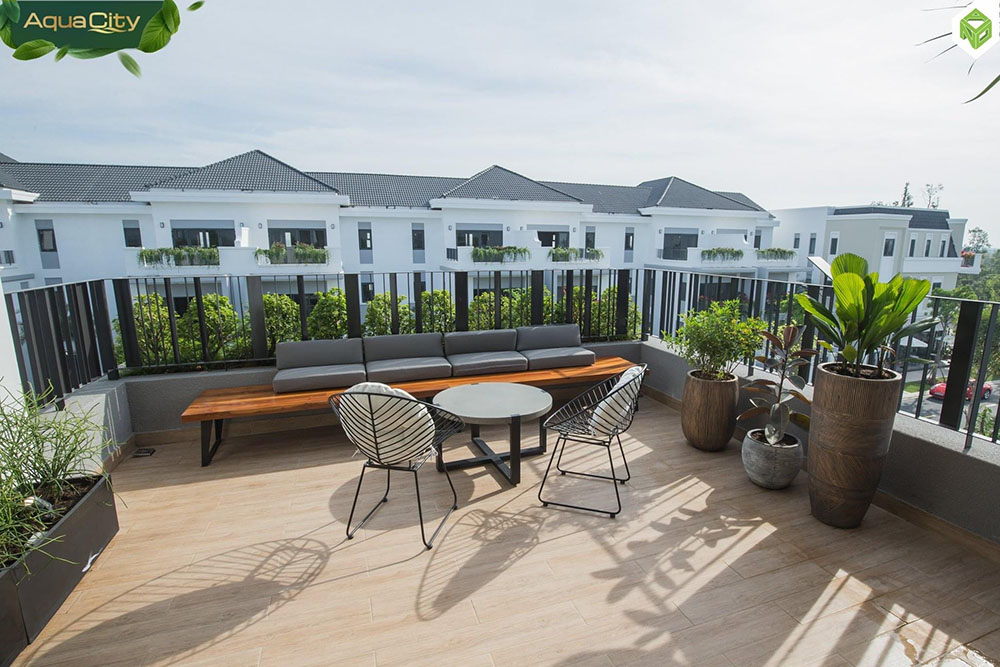 Hình ảnh thiết kế ban công mang tính minh họa, bố trí không gian thư giãn với bàn ghế nhỏ, mảng xanh và khu vực sinh hoạt ngoài trời; phù hợp làm nơi nghỉ ngơi, sân vườn mini hoặc BBQ nhẹ cho gia đình.